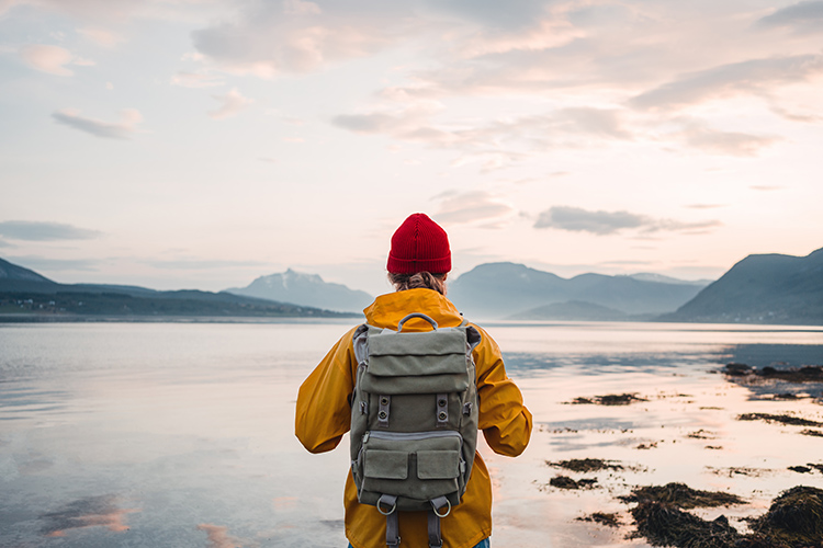 traveler wearing yellow jacket with backpack explore nature